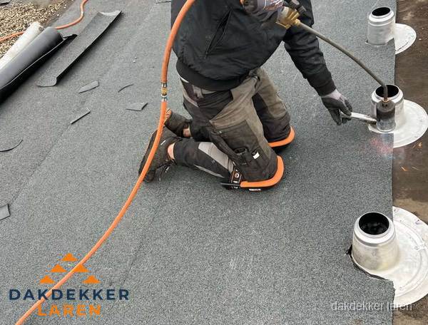Dakdekker repareert bitumen dakleer bij dakdoorvoer in Laren Dakdekker repareert bitumen dakleer bij dakdoorvoer in Laren
