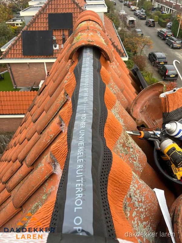 Dakdekker vervangt nokvorst met ruiterrol op pannendak in Laren