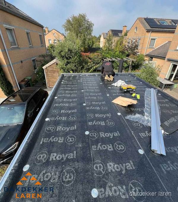 Dakdekker aan het werk op plat dak renovatie in Laren