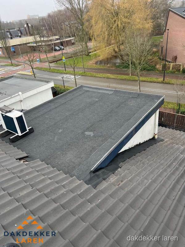 Plat dak met bitumen dakbedekking naast schuin pannendak in Laren Plat dak met bitumen dakbedekking naast schuin pannendak in Laren