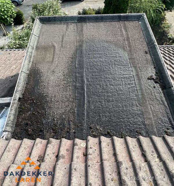 Verouderd plat dak met bitumen en slijtage voor lekkage inspectie in Laren Verouderd plat dak met bitumen en slijtage voor lekkage inspectie in Laren