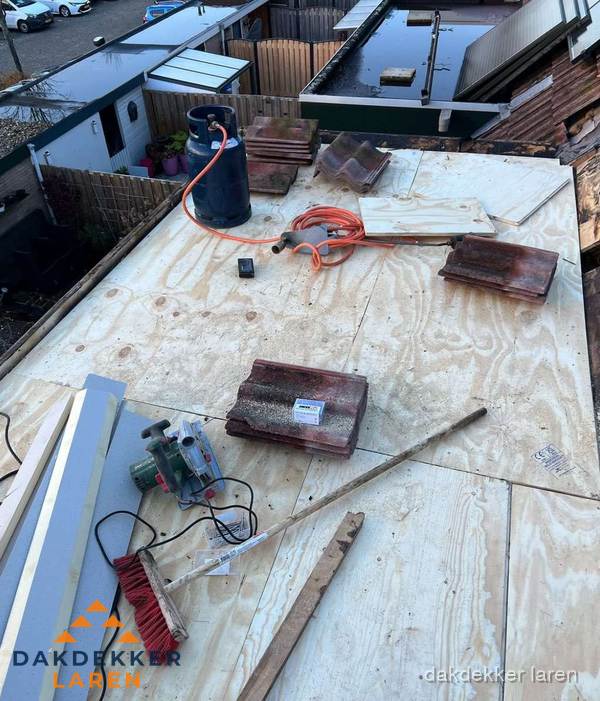 Dakreparatie werkzaamheden op plat dak met gereedschap in Laren