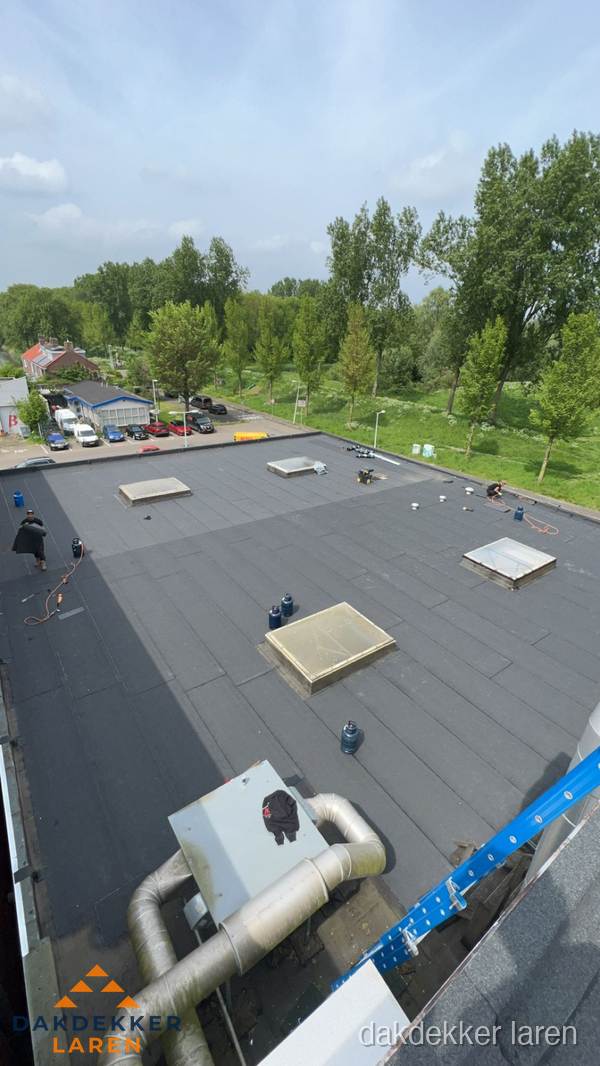 Dakdekker aan het werk op groot plat dak met bitumen in Laren Dakdekker aan het werk op groot plat dak met bitumen in Laren