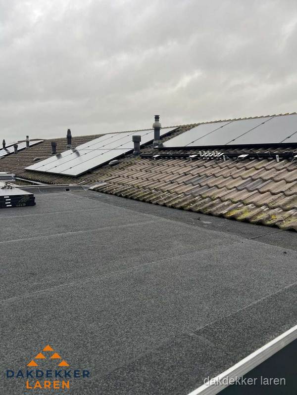 Bitumen dakbedekking op plat dak met aansluitend pannendak en zonnepanelen in Laren Bitumen dakbedekking op plat dak met aansluitend pannendak en zonnepanelen in Laren