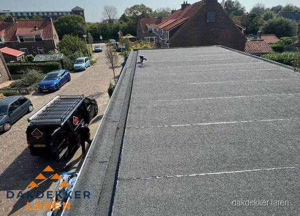 Nieuw bitumen plat dak met uitzicht over woonwijk in Laren