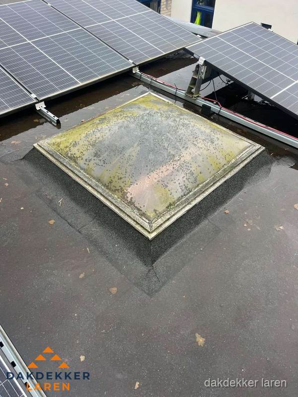 Vervuilde lichtkoepel op plat dak met zonnepanelen in Laren Vervuilde lichtkoepel op plat dak met zonnepanelen in Laren