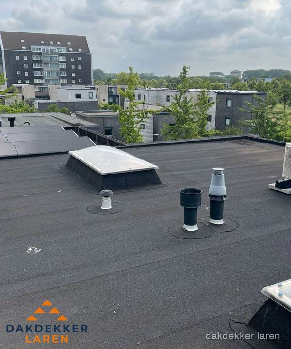 Groot plat dak met lichtkoepel en dakdoorvoeren in Laren Groot plat dak met lichtkoepel en dakdoorvoeren in Laren