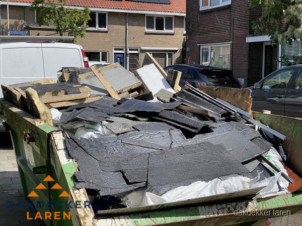 Afvalcontainer met gesloopt dakmateriaal tijdens dakkapel renovatie in Laren