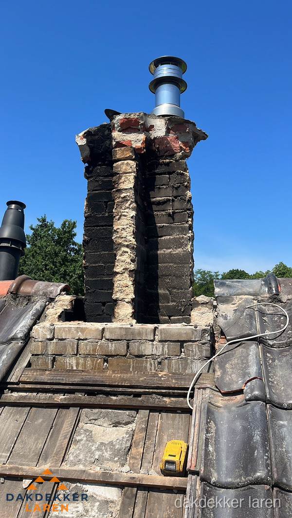 Beschadigde schoorsteen met nieuwe rookgasafvoer op oud dak in Laren Beschadigde schoorsteen met nieuwe rookgasafvoer op oud dak in Laren