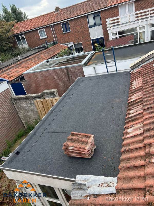 Aanbouw plat dak met reservepannen voor dakpannen vervangen in Laren