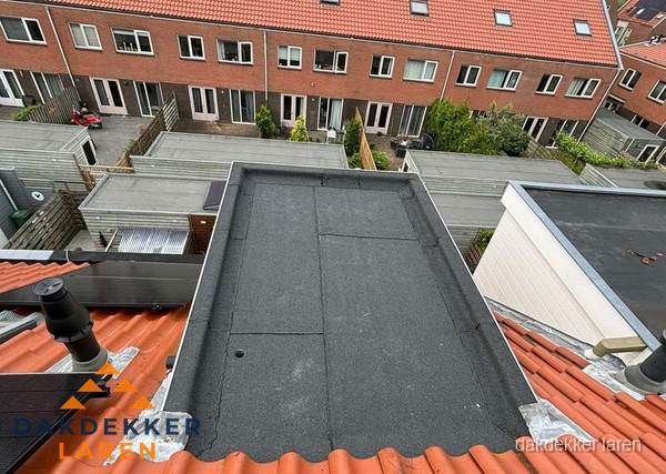 Plat dak met bitumen bedekking naast dakkapel in Laren
