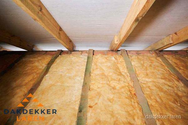 Dakisolatie met glaswol tussen dakspanten in Laren