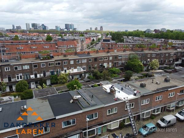 Spoed dakdekker aan het werk op plat dak in woonwijk Laren